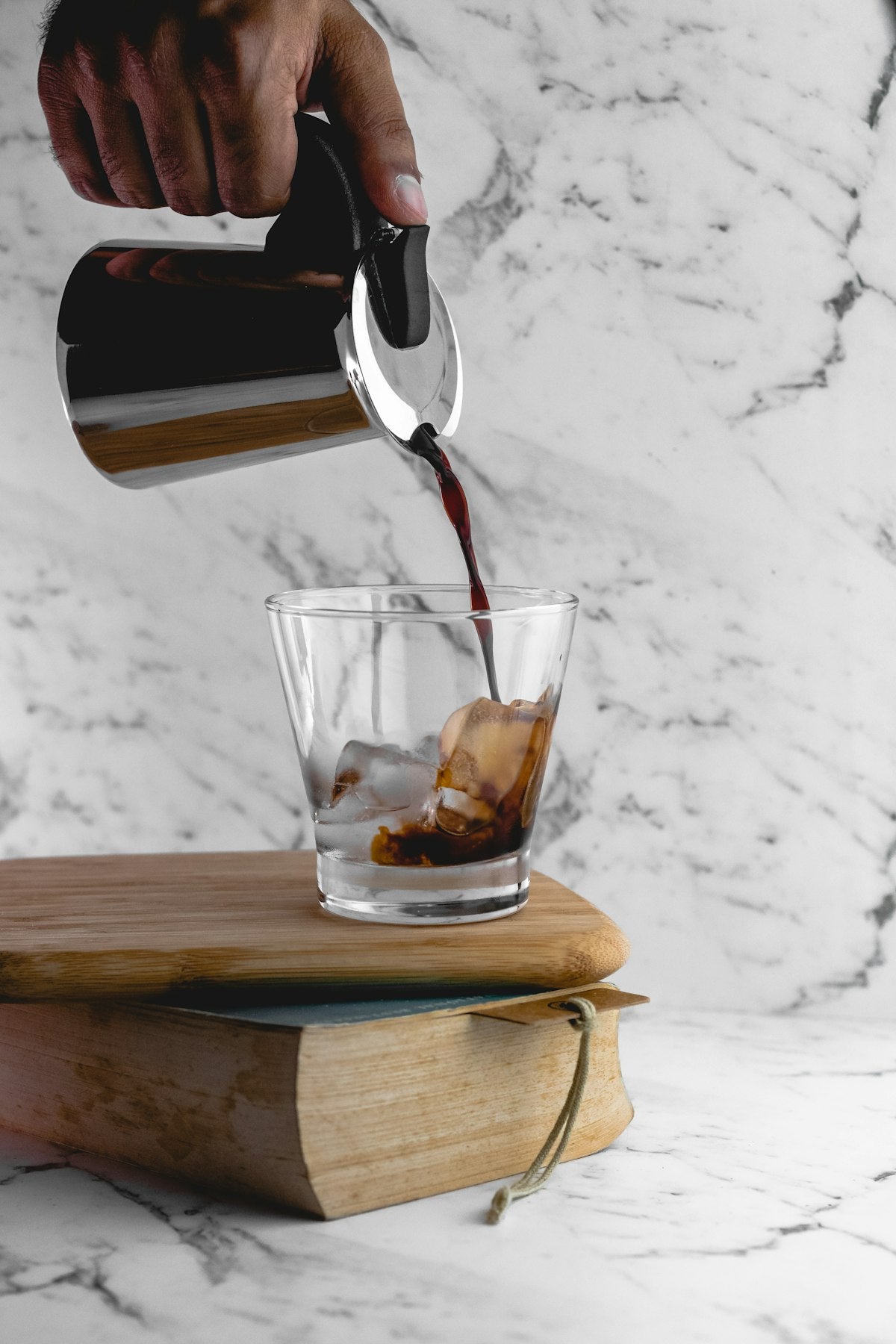 Cold brew coffee being poured over ice in a glass